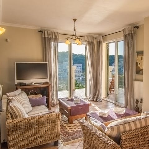 Relax on the comfy rattan sofas in the bright living space