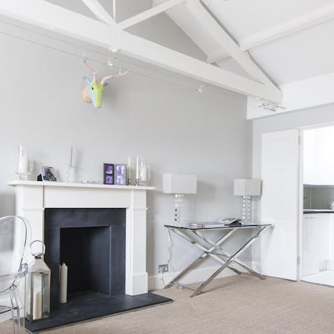 Relax in a characterful living room with rustic painted beams and an ornamental fireplace