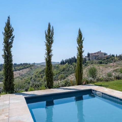 Admire views of a hilltop town from the private pool