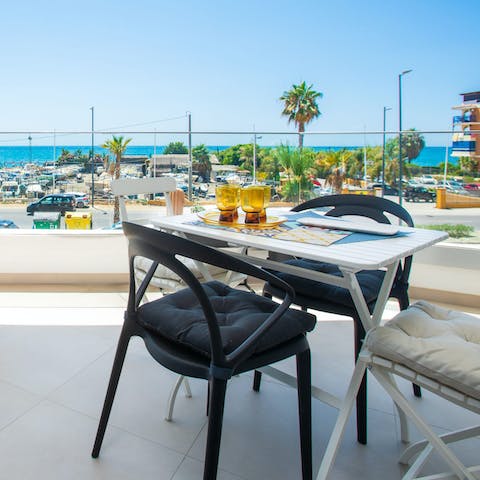 Admire the sea views from the private balcony, a glass of wine in hand