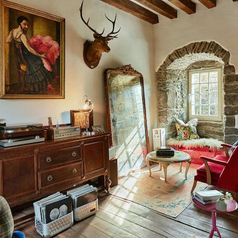 Listen to your favourite tunes on the record player amidst the living room's quirky designs and artwork