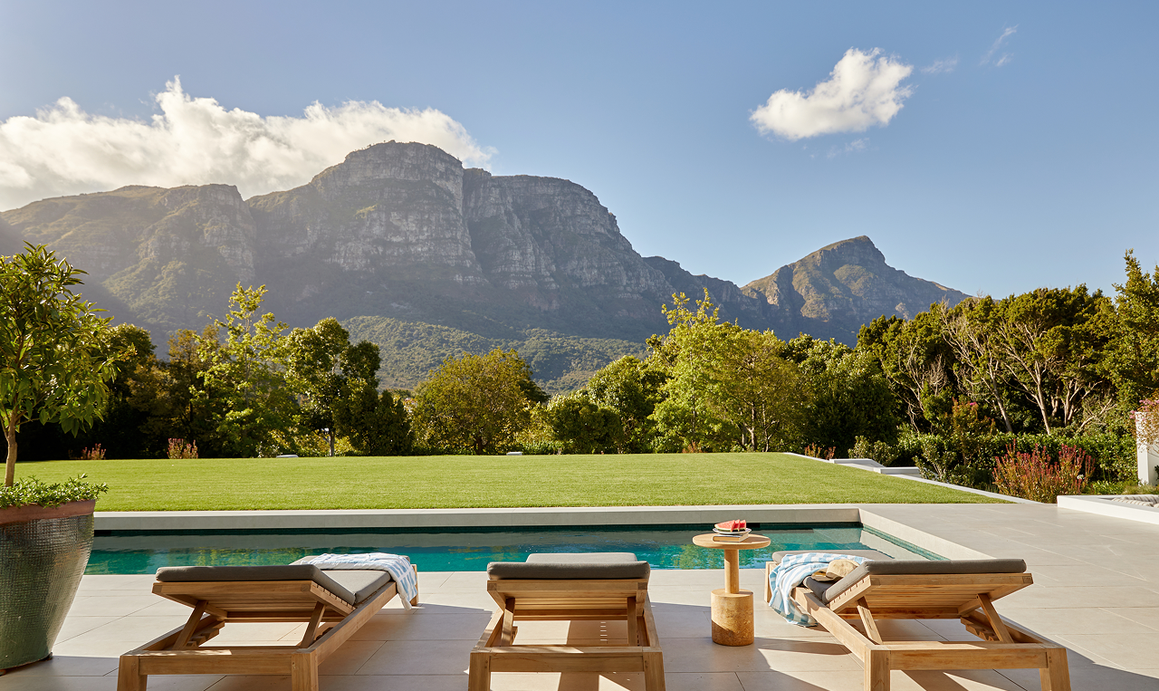 Outdoor pool terrace with sun loungers overlooking a mountain landscape